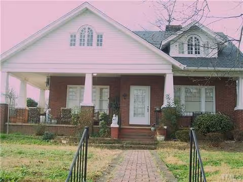 Brick senior living home with a covered front porch and brick walkway.