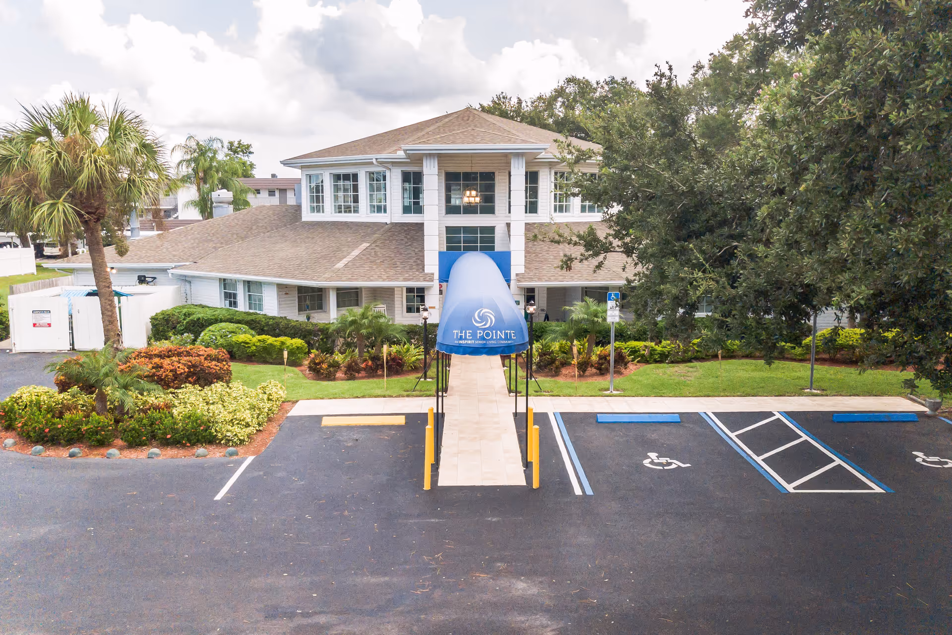 Exterior view of The Pointe senior living facility with parking lot and entrance walkway.