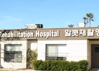 Exterior view of Alcott Rehabilitation Hospital building with a large sign.