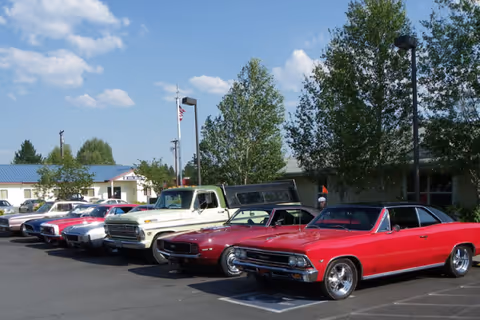 Parking lot in front of Prairie House Assisted Living and Memory Care with vintage cars.