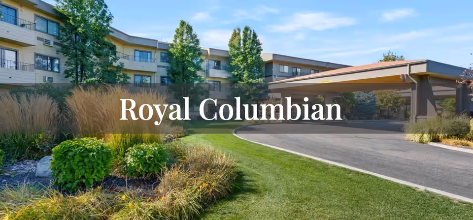 Landscaped front lawn and driveway leading to the covered entrance of the Royal Columbian senior living building.