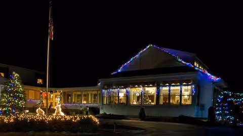 Exterior view of Bel-Air Nursing Home at night with festive holiday lights.