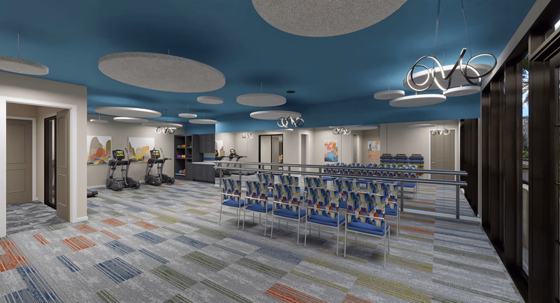 Spacious interior activity room with rows of patterned chairs, treadmills along the wall, colorful carpeting, and modern ceiling lights.