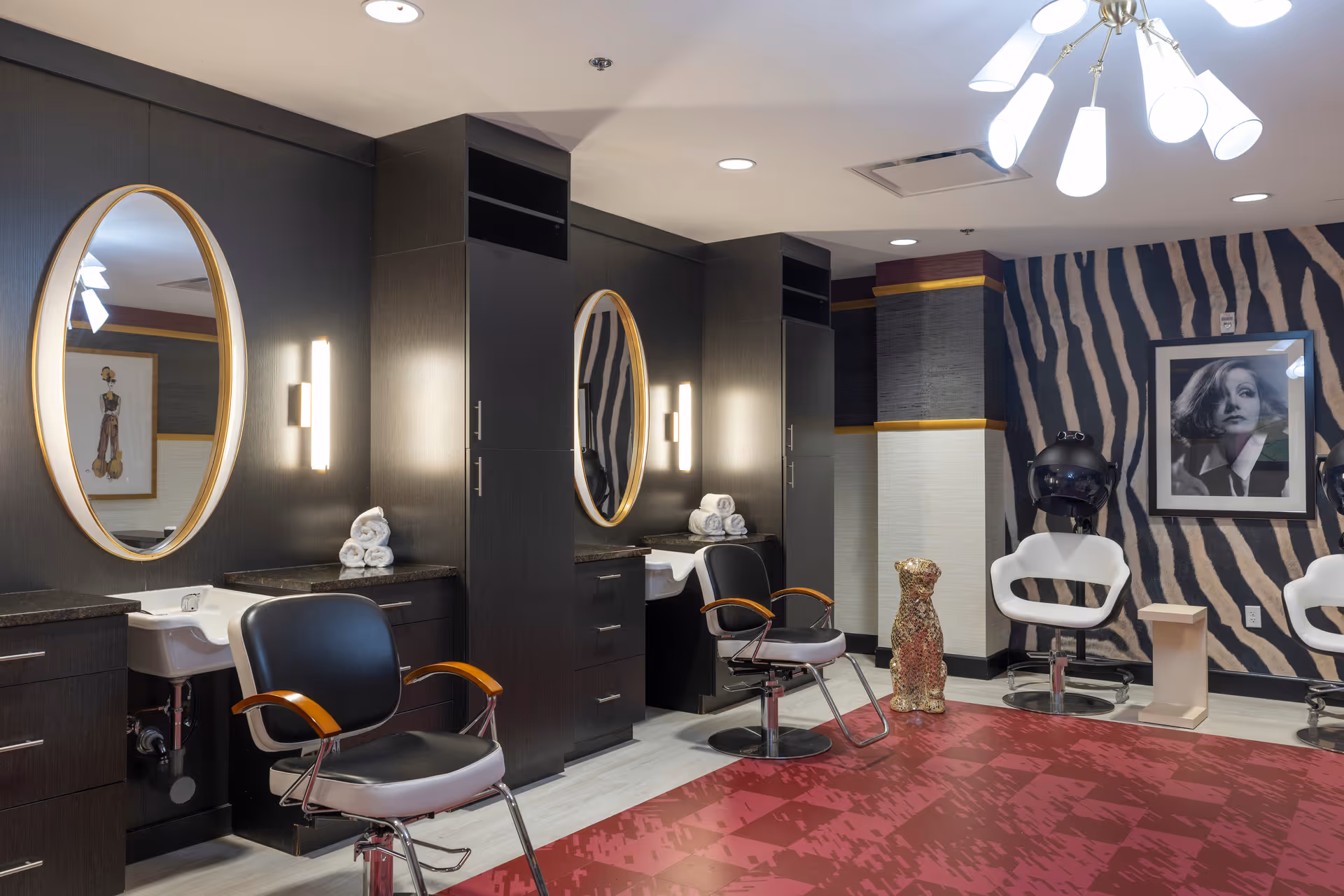 Stylish salon interior with styling chairs, oval mirrors, sinks, and hair dryer stations.