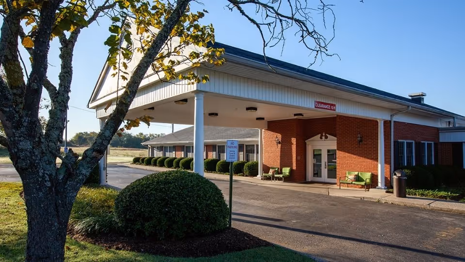 Exterior view of the Eaton Creek Post Acute senior living facility with landscaped entrance.