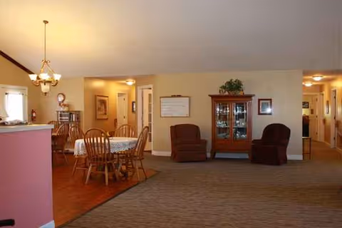 Spacious senior living interior with a dining table and comfortable armchairs.