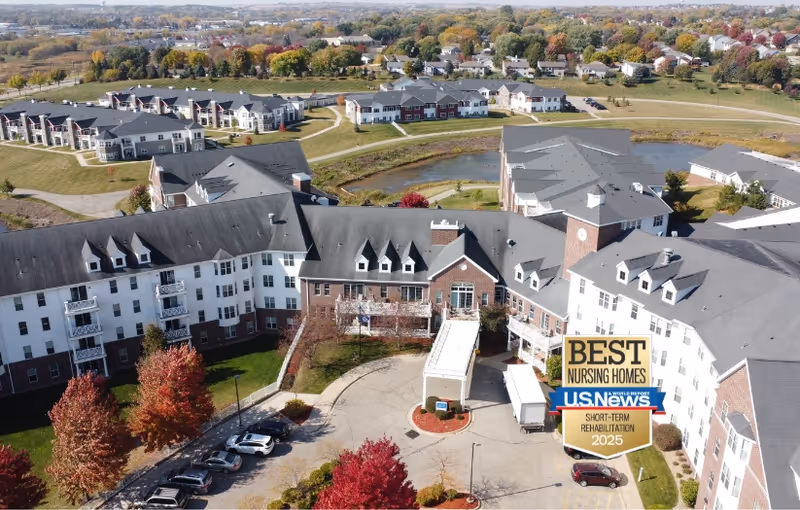 Aerial view of the Horizons Care Center with the main entrance canopy, circular driveway, connected residential buildings, pond and fall foliage.