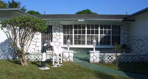Front exterior of Eleanors Retirement Home with stone facade, large windows, and a horse sculpture.