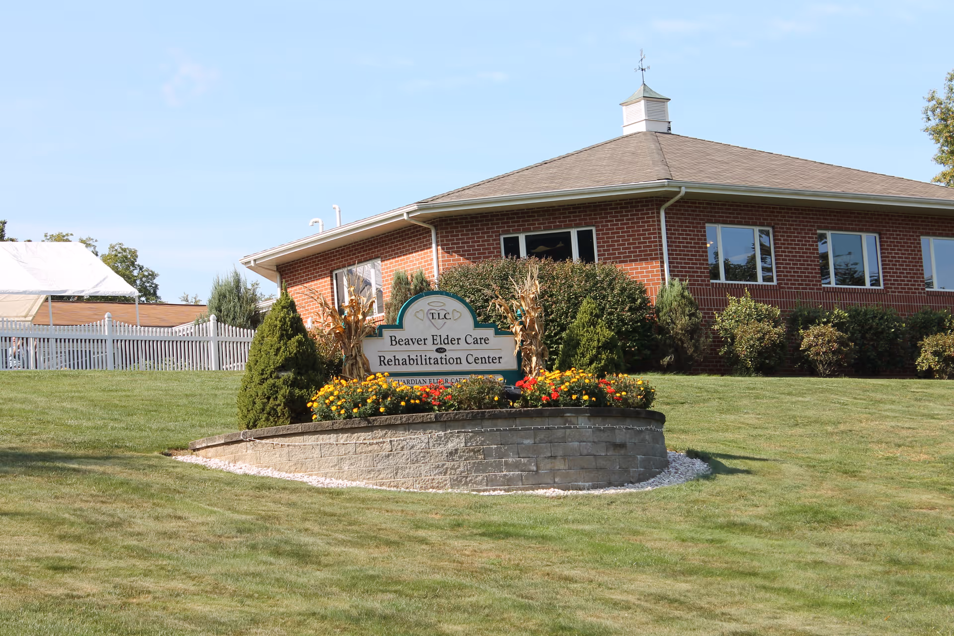Brick rehabilitation center building with a landscaped sign reading 'Beaver Elder Care Rehabilitation Center' on a grassy lawn.