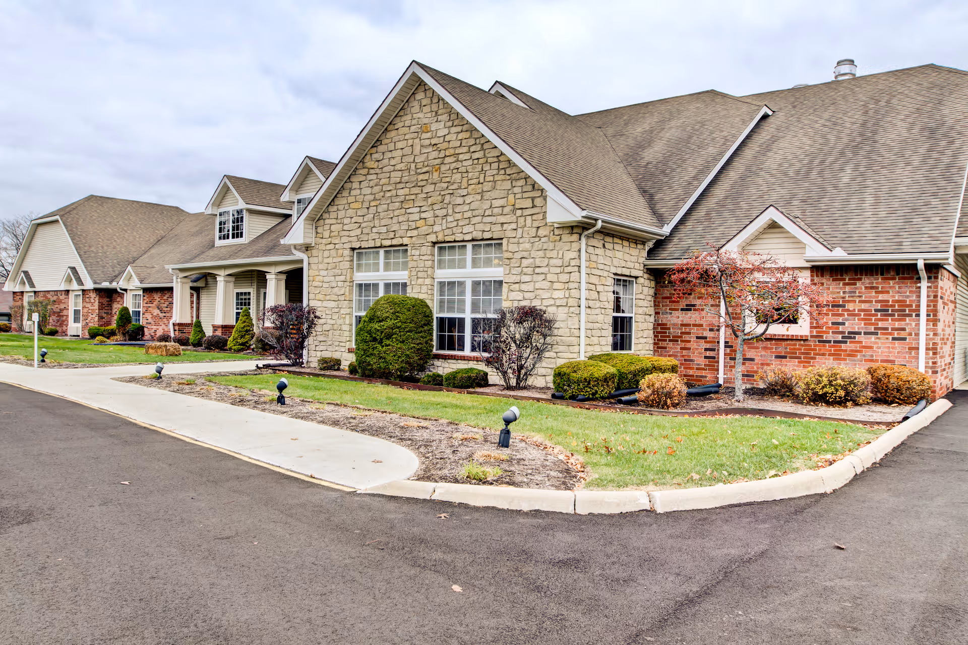 Exterior view of Brookdale Mansfield: a single-story facility with stone and brick facade and manicured landscaping.