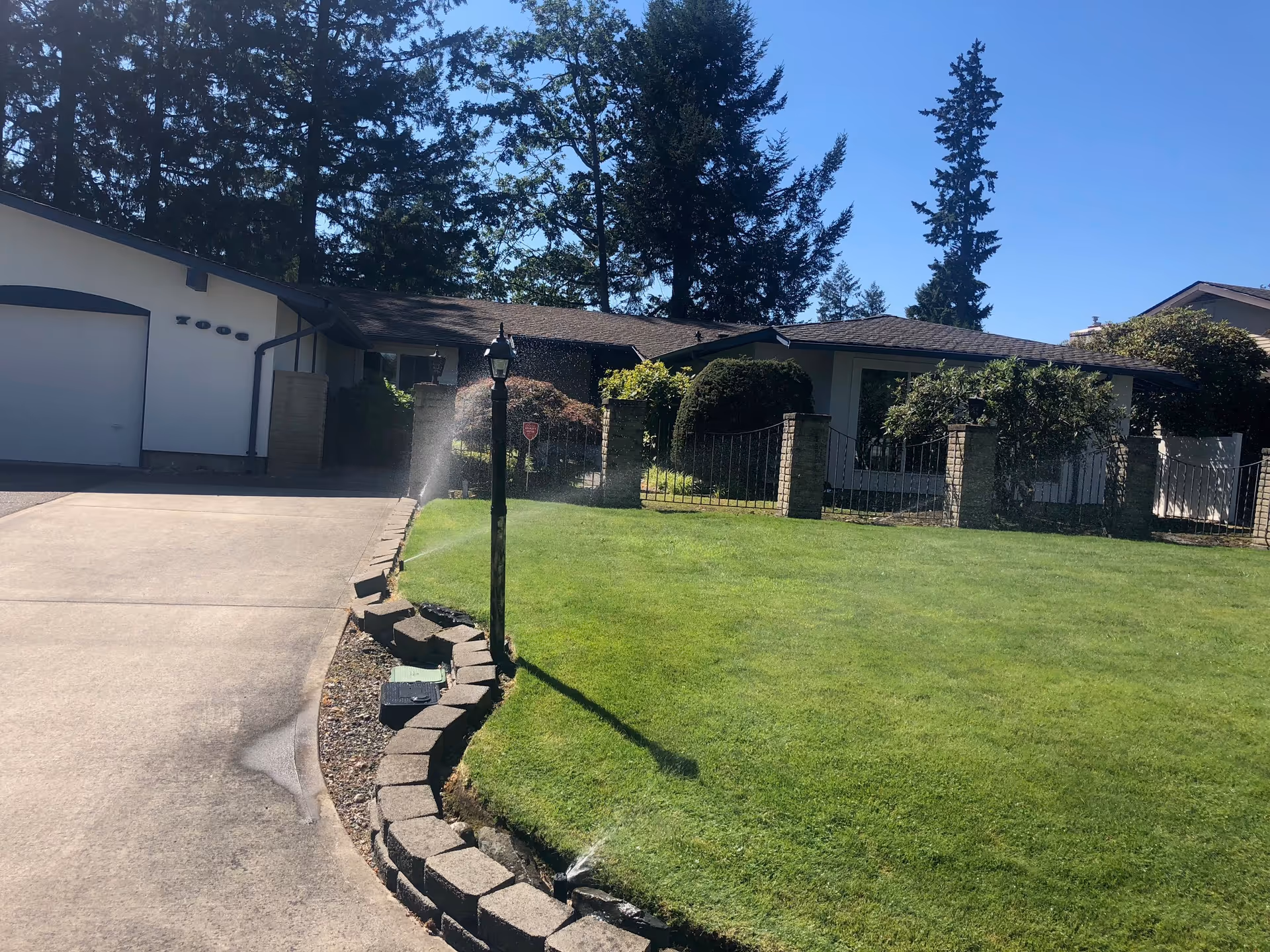 Single-story facility exterior with a green lawn, driveway, and gated entrance.