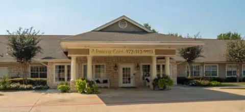 Front view of a Brookdale Creekside memory care facility entrance with columns and planters.