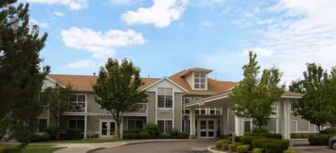 Exterior view of Brookdale Boise Parkcenter, a senior living facility, with a curved driveway and trees.