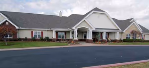 A single-story senior living facility exterior with a covered entrance and manicured landscaping.