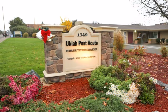Stone entrance sign reading "Ukiah Post Acute Rehabilitation Services" (1349) surrounded by landscaped beds in front of the facility.