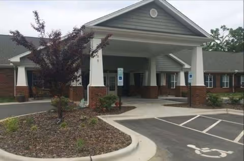 Exterior view of Brookstone Retirement Center with a covered entrance and accessible parking.