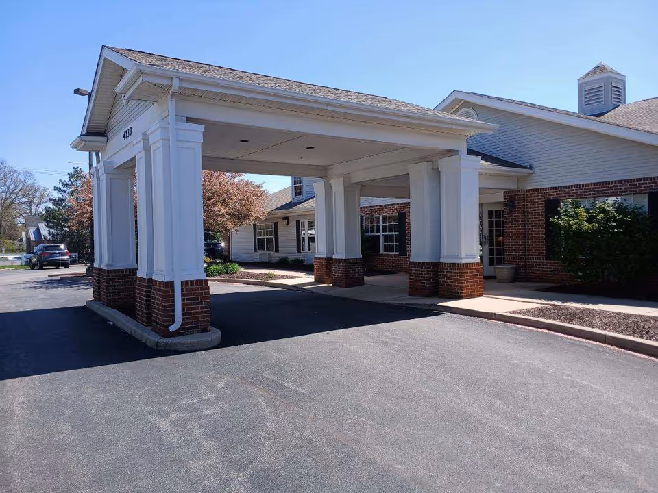 White-columned entrance canopy over brick columns at The Terrace at Ft Wayne.