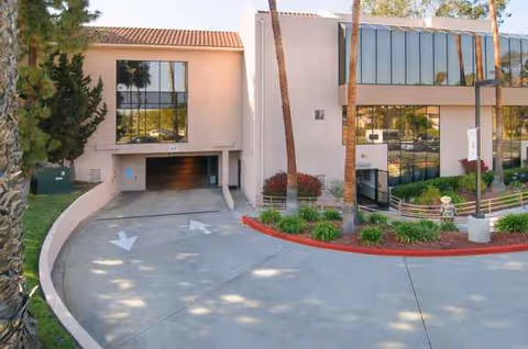 Exterior view of Life Care Center of Vista with curved driveway and palm trees