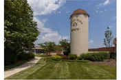 Exterior view of Brittany Pointe Estates with a tall cylindrical sign and manicured lawn.