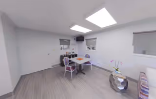 A bright dining area with a table and chairs, featuring modern decor.