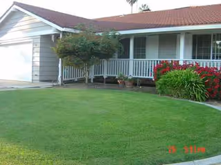 Front view of Remmington Place: single-story building, white porch, red roof, green lawn.