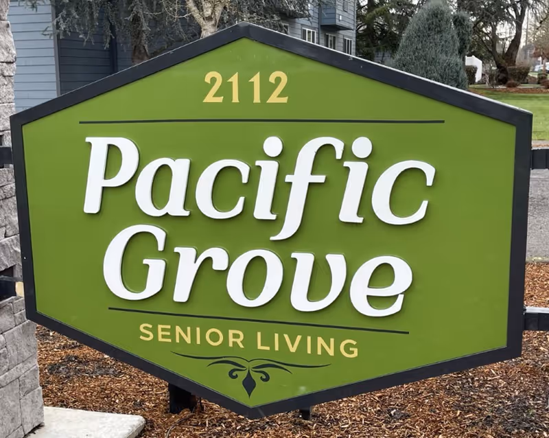 Green entrance sign reading "Pacific Grove Senior Living" with the address number 2112.