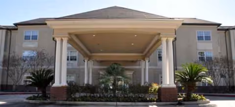 Front entrance of Brookdale Cypress Station with a covered porte-cochere and landscaping.