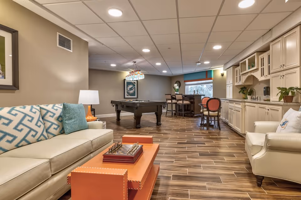 Spacious furnished common lounge with sofas, a pool table, bar seating and a kitchenette.