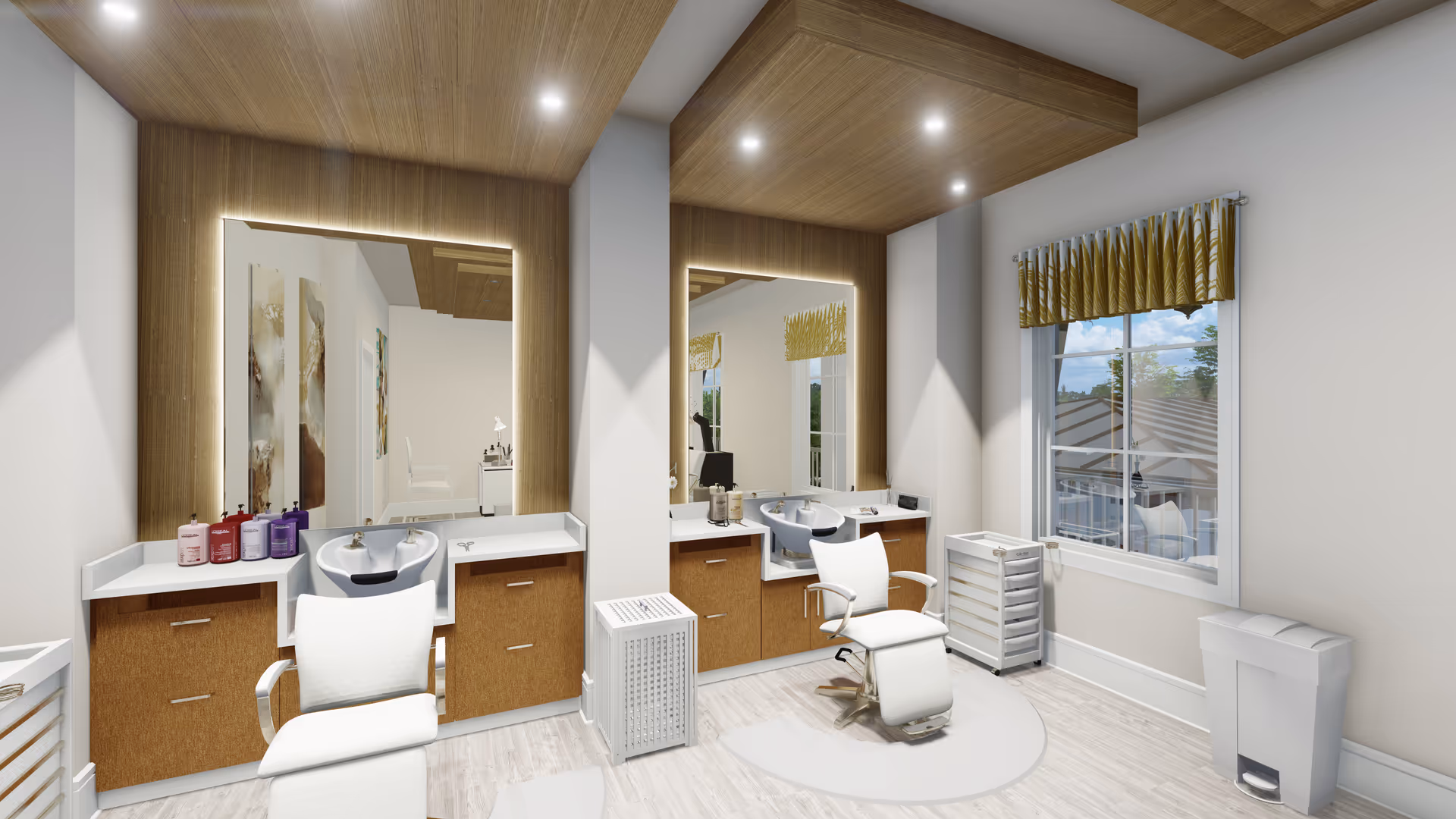 A modern hair salon area with two white salon chairs in front of two large mirrors framed with wood and backlit lighting. Each station has a white countertop with brown cabinets underneath, a white sink for hair washing, and various hair care products. The room has light-colored wood flooring, a window with a yellow patterned valance, and a trash bin near the window.