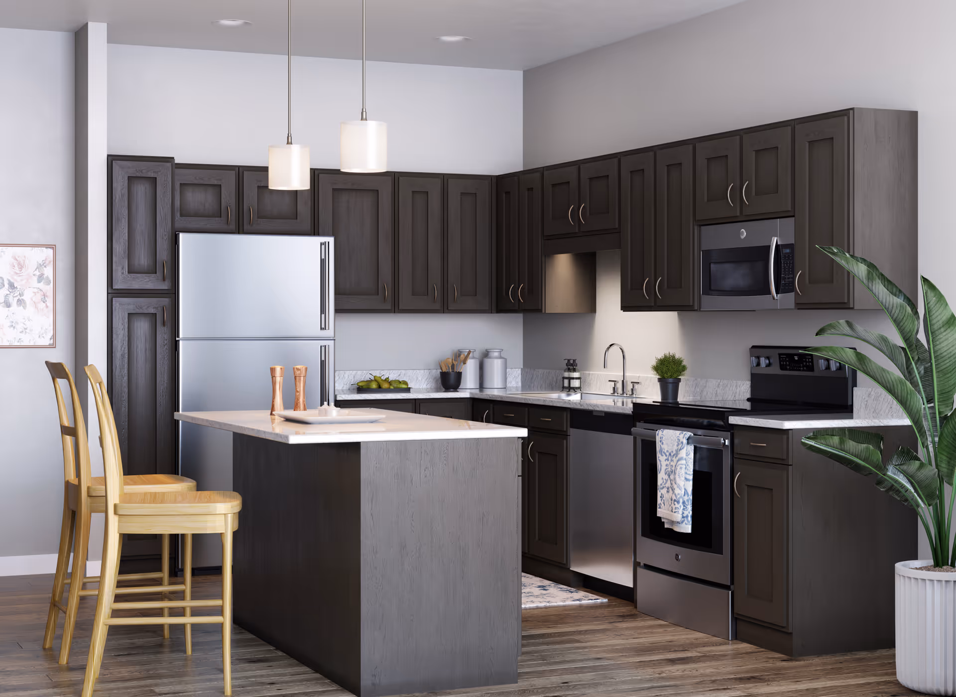 Modern kitchen with dark wood cabinets, stainless steel refrigerator, oven, microwave, and dishwasher. A kitchen island with a light countertop has two wooden chairs. Two pendant lights hang above the island. There is a potted plant on the right side near the cabinets and a framed floral picture on the left wall.