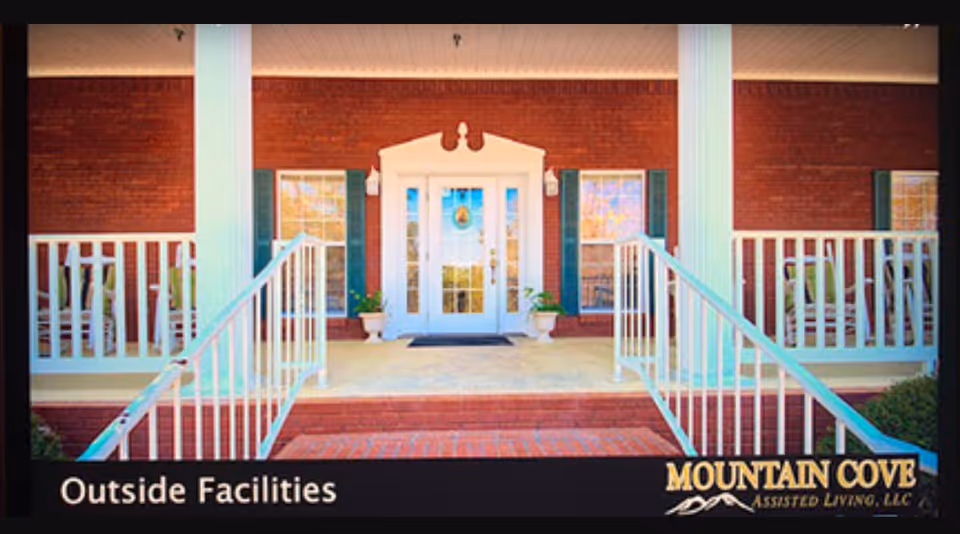 Front entrance of Mountain Cove Assisted Living with brick facade, white pillars, and steps.