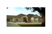 Exterior view of Ganado Nursing & Rehab Center, a single-story beige building with a driveway.