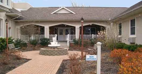 Front exterior of Springview Manor showing a path, porch, and circular fountain.