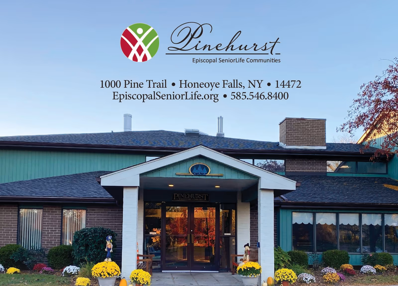 Front exterior view of Pinehurst, Episcopal SeniorLife Communities building with a covered entrance, brick and green siding, and landscaped flowers and shrubs in front.