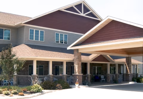 Exterior view of Copper Creek Senior Living facility with a covered entrance and landscaping.