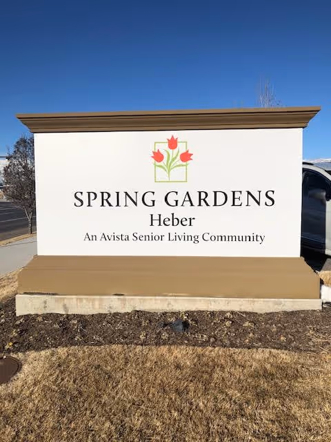 Outdoor sign for Spring Gardens Heber, an Avista Senior Living Community, featuring a logo with three red tulips above the text.