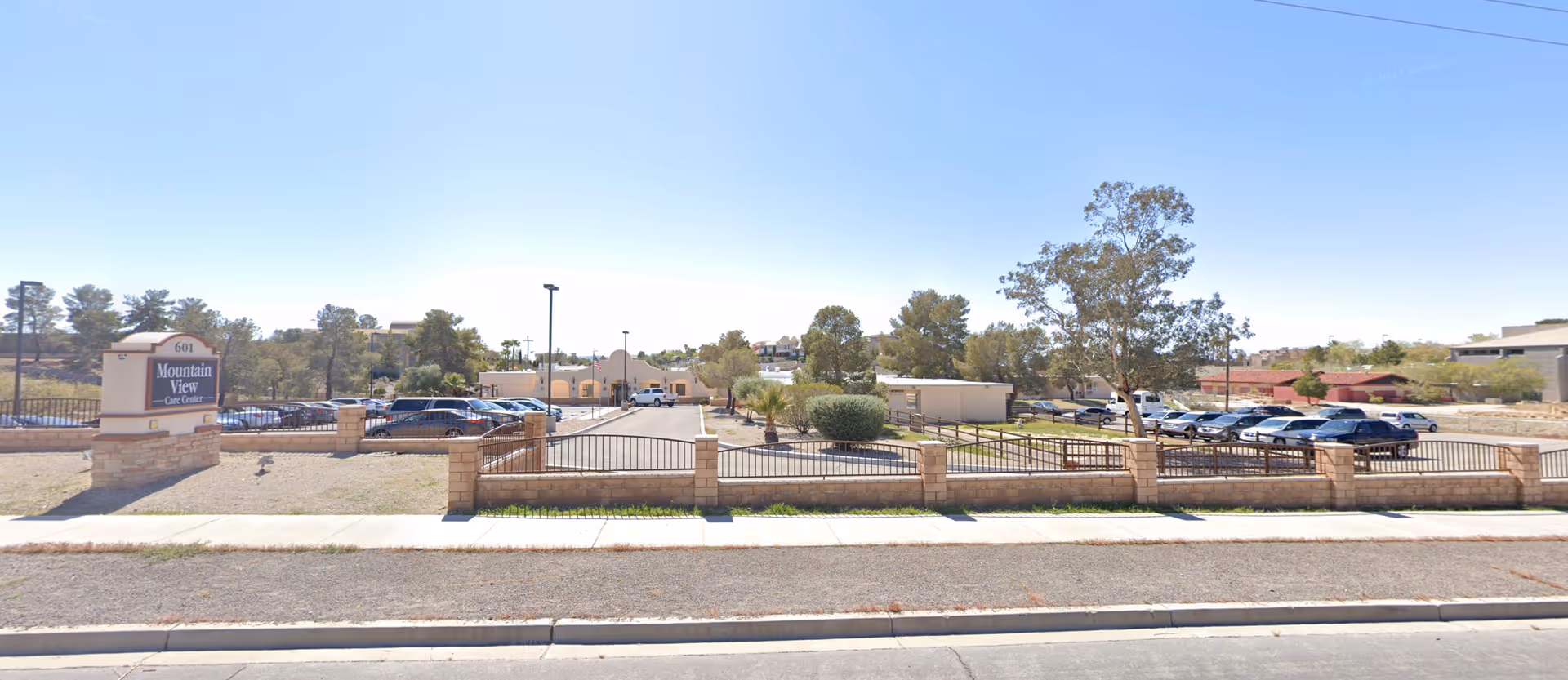Front exterior view of the Mountain View Care Center showing the entrance, parking lot, and property sign.