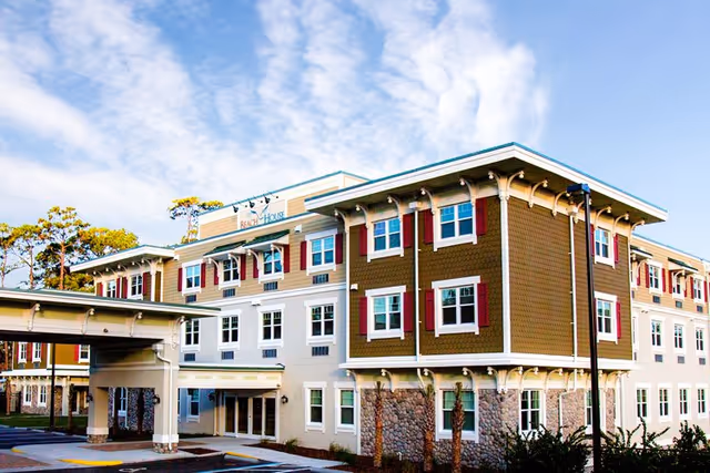 Exterior view of Beach House Assisted Living & Memory Care building with multiple windows and entrance.