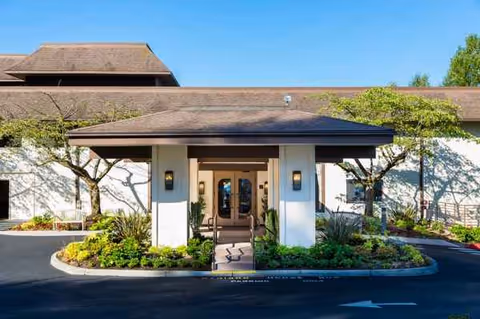 Front entrance of Madison House Assisted Living Community with a landscaped walkway.