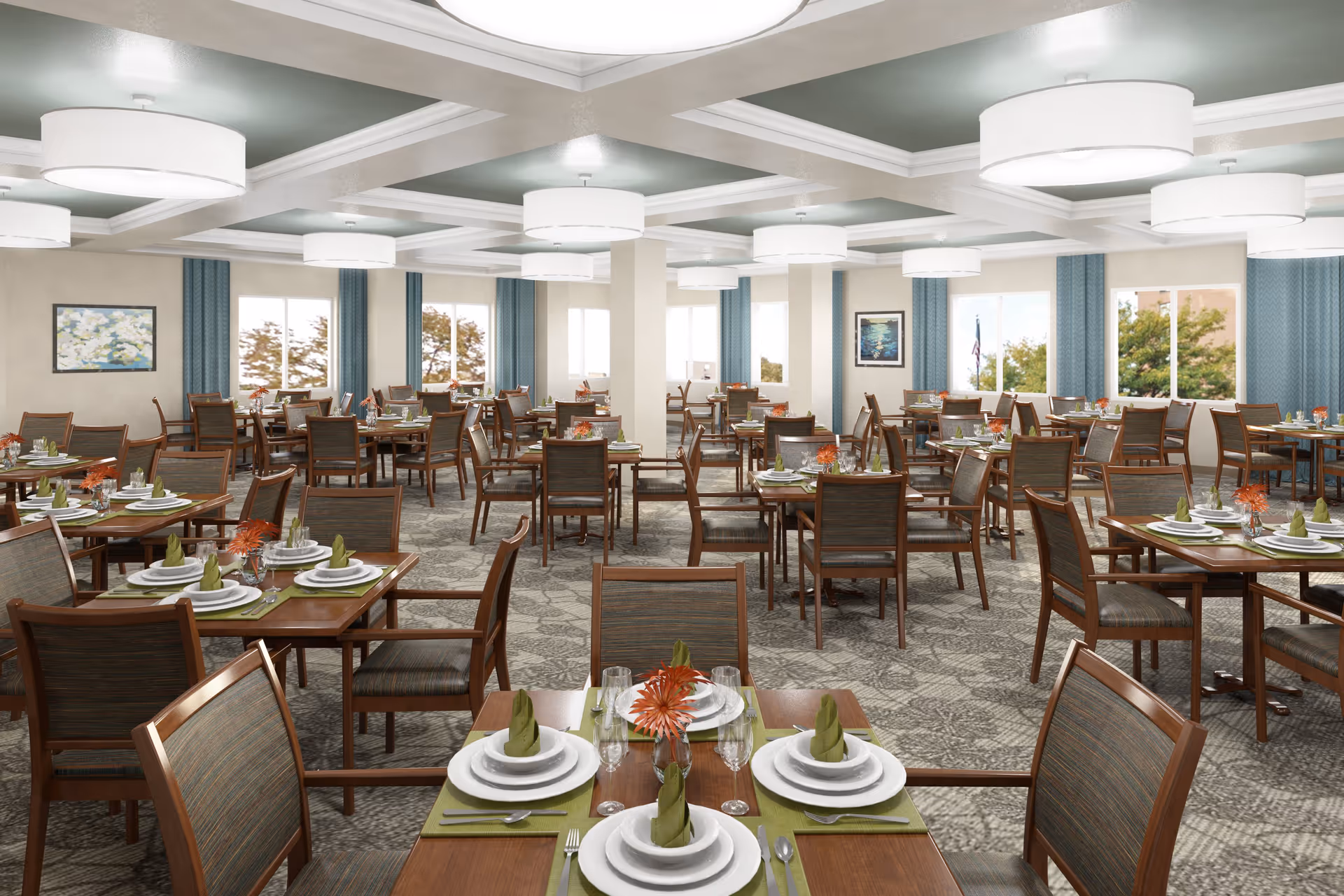 A spacious dining room with multiple wooden tables and chairs arranged neatly. Each table is set with white plates, green napkins folded upright, silverware, and glasses. There are small orange flower centerpieces on each table. The room has large windows with blue curtains, light-colored walls, and a patterned carpet. Modern circular ceiling lights provide illumination.