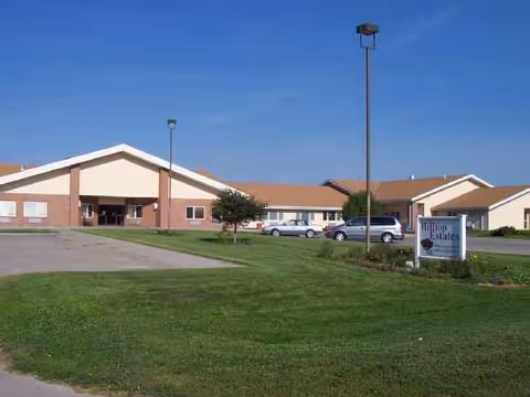 Exterior view of a single-story senior care center with a parking lot and lawn.