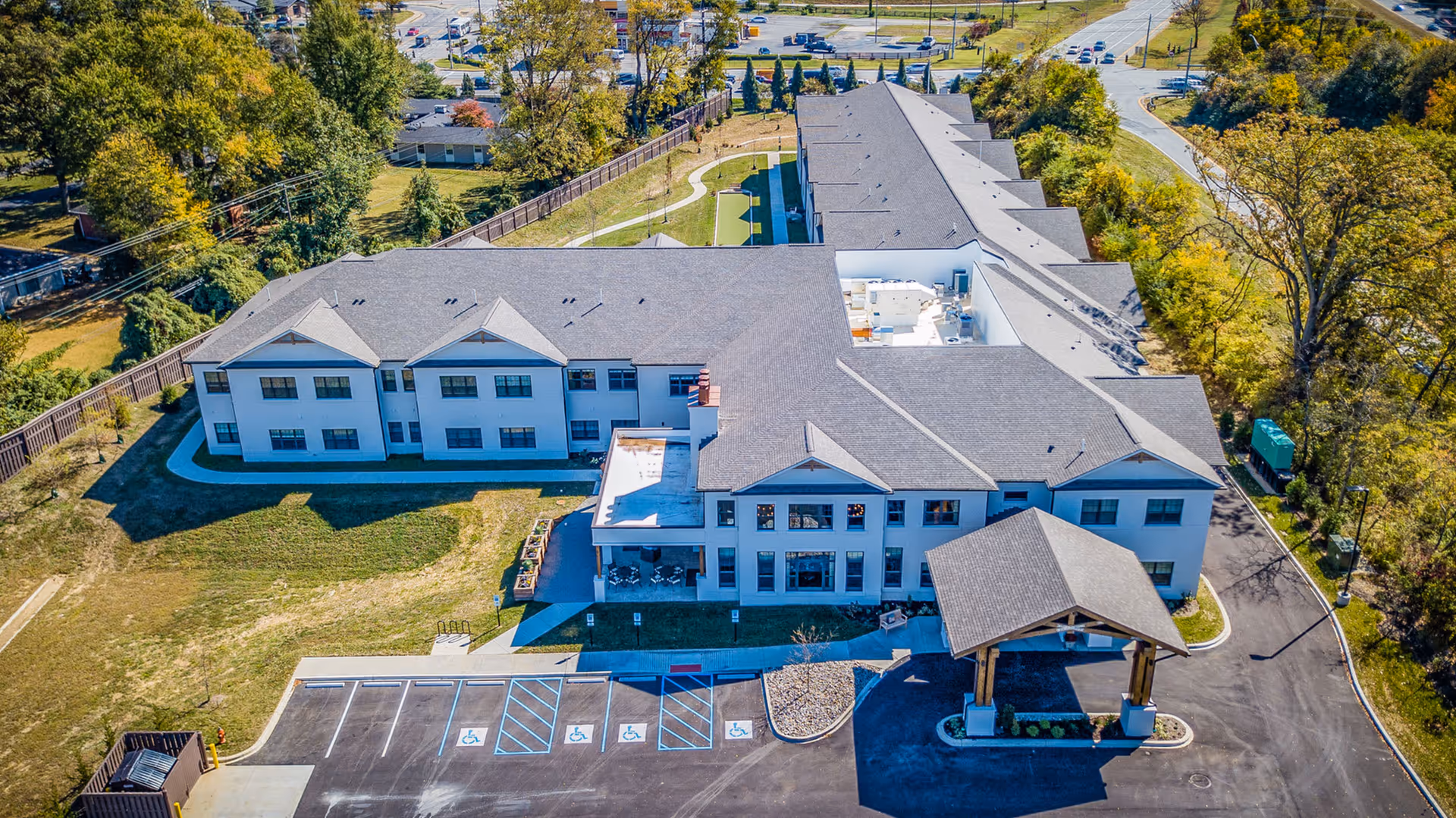 Aerial view of the Everlan of Louisville senior living building showing the entrance canopy, parking lot with handicap spaces, and surrounding grounds.