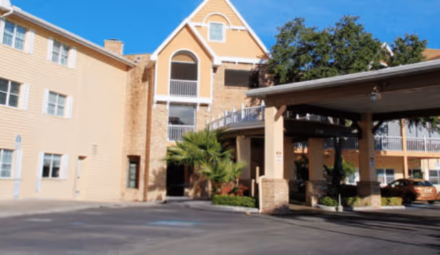 Exterior view of Bayside Terrace showing the front entrance, covered drop-off, and parking area.
