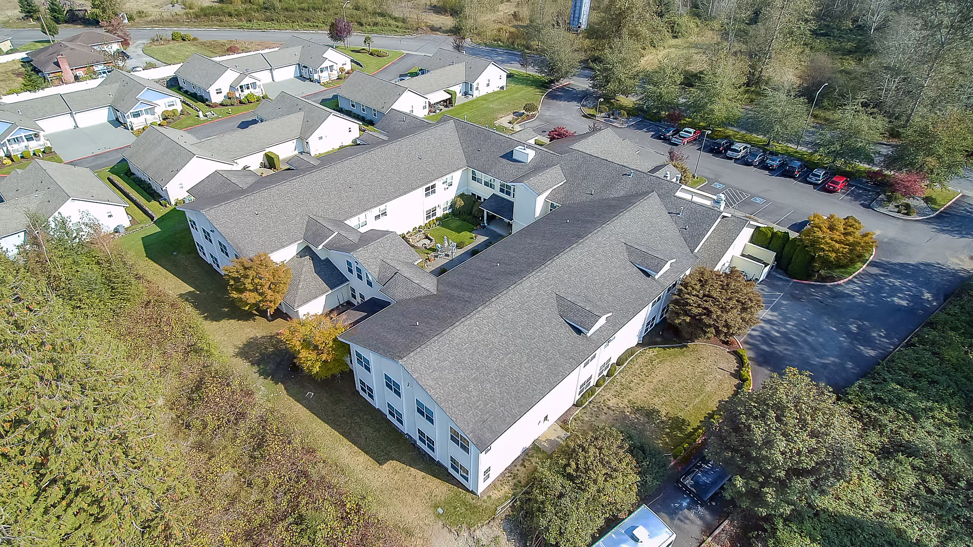 Aerial view of Cascade Place Assisted Living memory care facility showing the main building, courtyard, parking lot and surrounding landscaping.