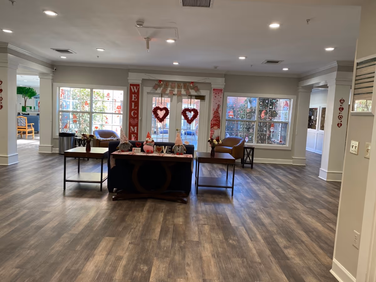 Spacious decorated lobby/common area with seating, tables, and Valentine's Day decorations.