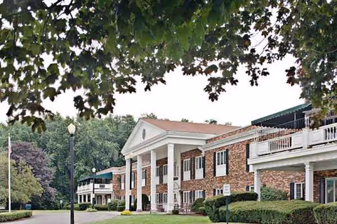 Exterior view of Agawam North Rehab and Nursing, a brick senior living facility.