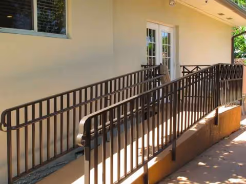 Exterior view of a building with a ramp and railing.