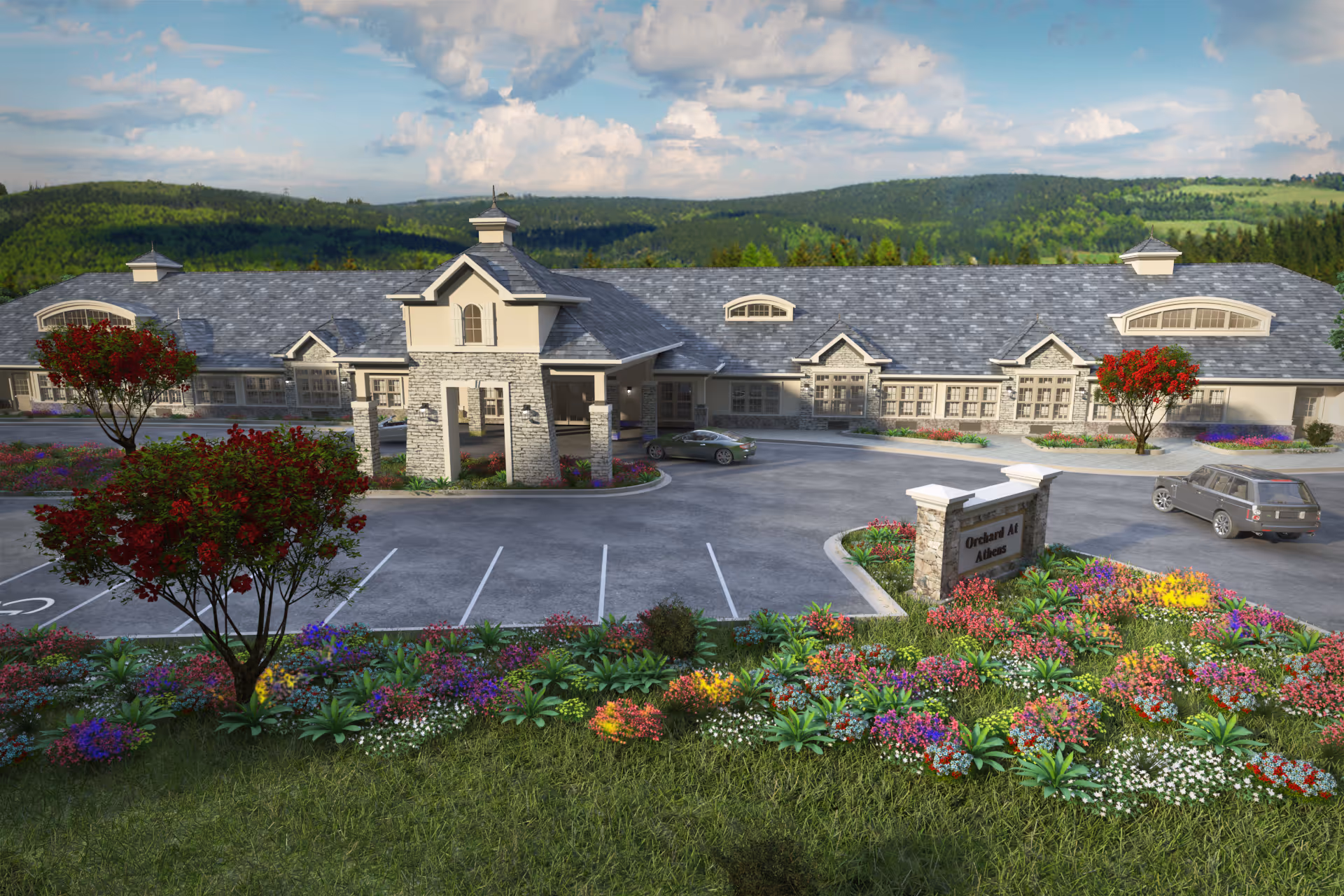 Exterior view of Orchard at Athens facility showing a large building with a stone entrance, surrounded by colorful flower beds and trees, with a parking lot and two cars in front. The background features green hills and a partly cloudy sky.