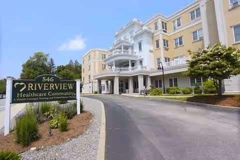 Exterior view of Riverview Rehabilitation & Healthcare Center, with driveway, entrance, and signage.