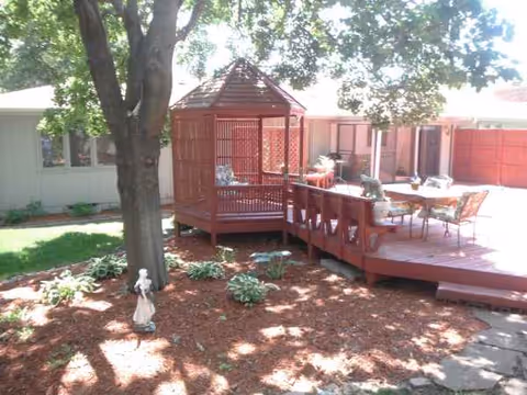 Outdoor patio with gazebo, tables, chairs, and residents relaxing outdoors.